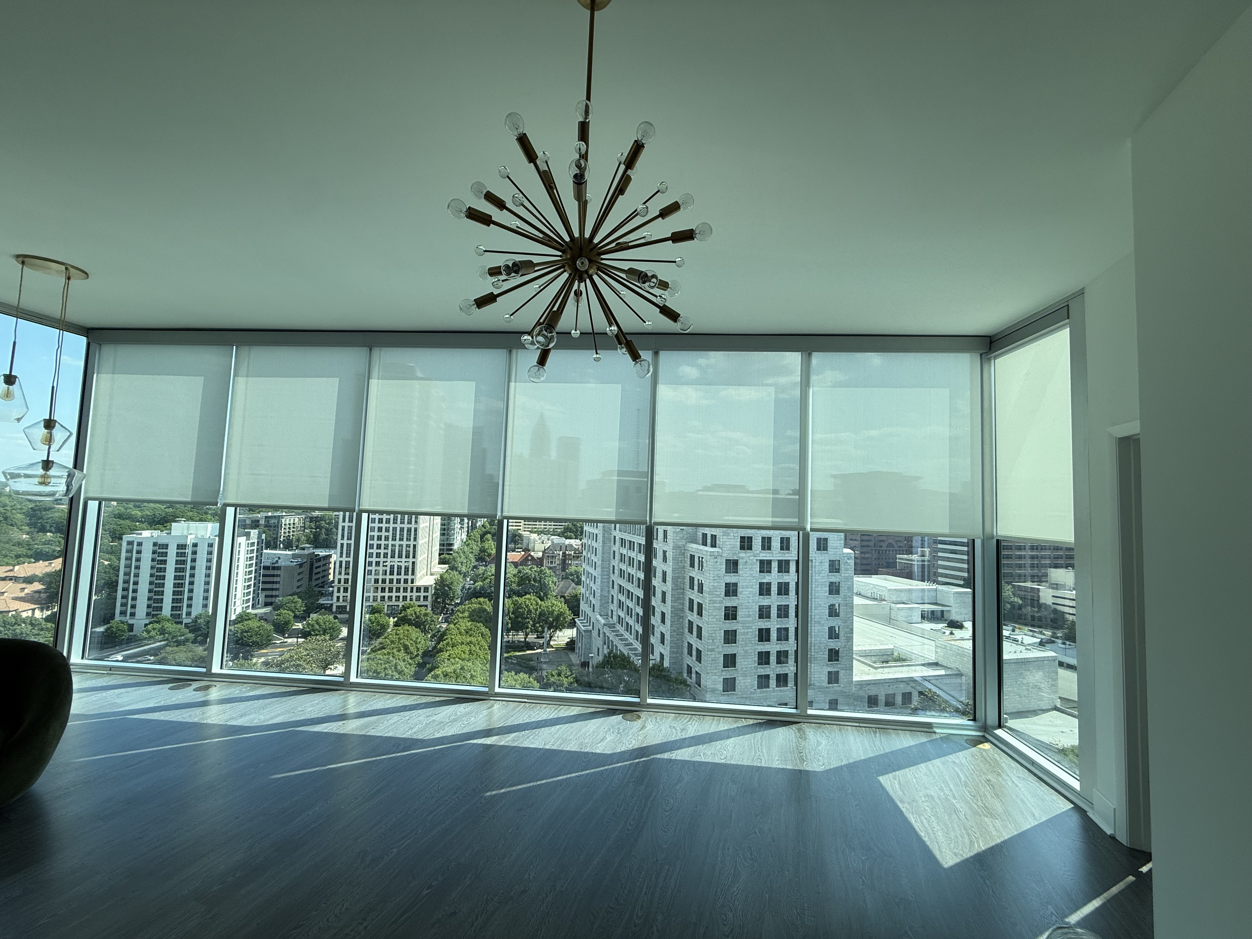 Roller shades in a skyline-view living room